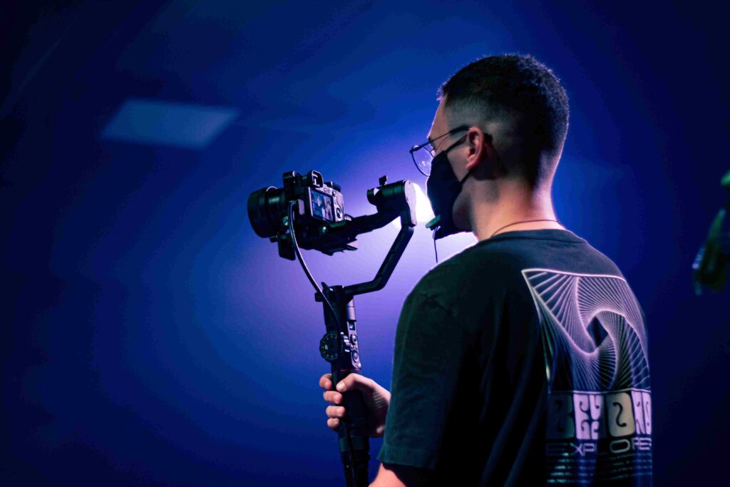 man holding a camera and a tripod